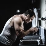 Rugged man practicing basic self-care by washing his face in a gritty concrete industrial setting. Dark moody high-contrast photography focused on masculine discipline and fundamentals. No fluff — pure signal.